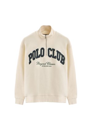 Crèmekleurige half-zip sweatshirt gemaakt van zachte stof. Voorzien van de tekst "POLO CLUB" en "Beyond Classics" in donkerblauw gedrukt op de borst.