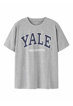 T-shirt gris à manches courtes avec "YALE" en grandes lettres bleu marine et "UNIVERSITY" en lettres blanches plus petites en dessous sur le devant.