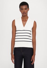 Débardeur en tricot sans manches blanc avec des rayures horizontales bleu marine, présentant un col en V et des bords côtes. Texture lisse, coupe décontractée.