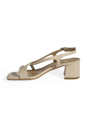 Beige heeled sandal with a square toe, open sides, and a slingback design. Material has a smooth texture with a chunky block heel.