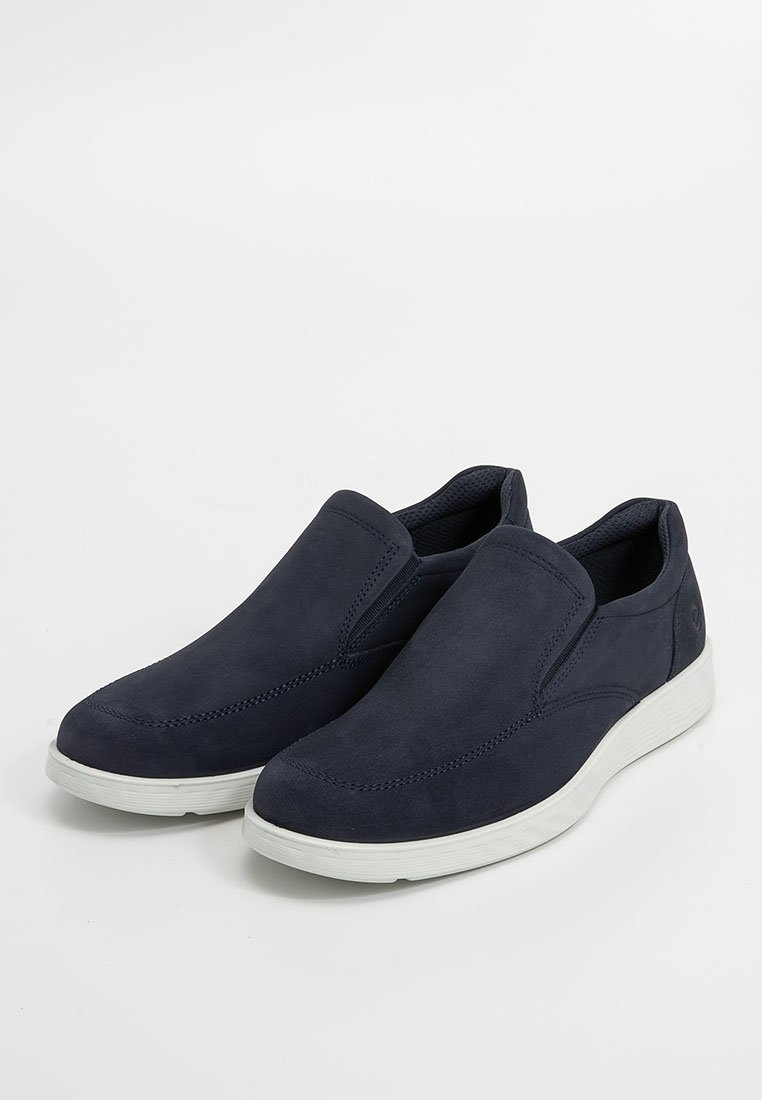 Granatowe slip-on zamszowe buty z elastycznymi bocznymi panelami i białą gumową podeszwą. Okrągły nosek i minimalne detale dla eleganckiego wyglądu.