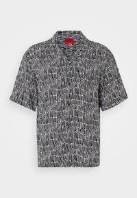 Short-sleeve, black and white patterned shirt with a camp collar and loose fit. Features a geometric design and a red HUGO tag at the collar.
