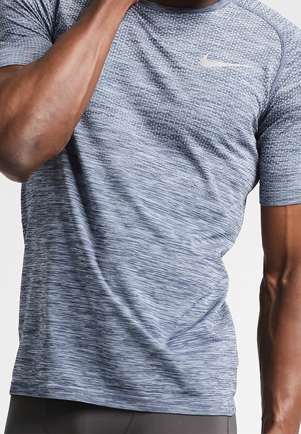 Navyblå träningsskjorta med en texturerad, horisontell mönstring och korta ärmar. Har en liten, ljusgrå Nike-logotyp på bröstet.