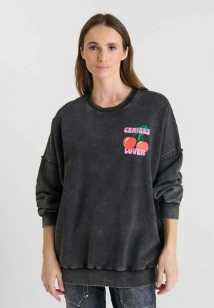 Grijze oversized sweatshirt gemaakt van zachte stof met een ronde hals, featuring een kleurrafische print die zegt "CERISES LOVER" met kersen.