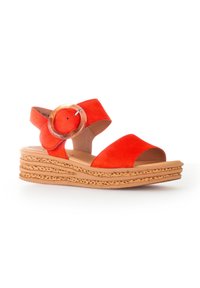 Rode suede sandaal met twee brede banden, een ronde decoratieve gesp en een gelaagde kurken wigzool voor extra hoogte.