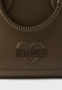 Καφέ τσάντα από συνθετικό δερματίνη με πλεκτή λαβή. Διαθέτει ανάγλυφο λογότυπο "LOVE MOSCHINO" σε σχήμα καρδιάς και ραφές σε αντίθετο χρώμα.