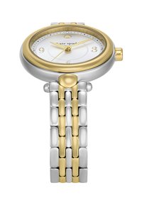 Analoge horloge met een zilver- en gouden roestvrijstalen armband. Ronde kast met een witte wijzerplaat, Arabische cijfers en glinsterende accenten om 12 uur.