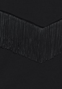 Černá tkanina s hladkou texturou má na horním okraji složitý řádek černých třásní, které vytvářejí efekt vrstveného designu.