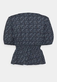 Černá blůza s malým modrým květinovým vzorem, s nafouknutými rukávy, nařaseným pasem a peplum lemem. Lehce materiál s jemnou texturou.