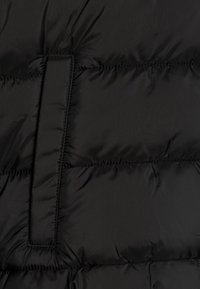 Black puffer jacket material with quilted texture, featuring a rectangular flap and visible stitching details. Lightweight and smooth finish.