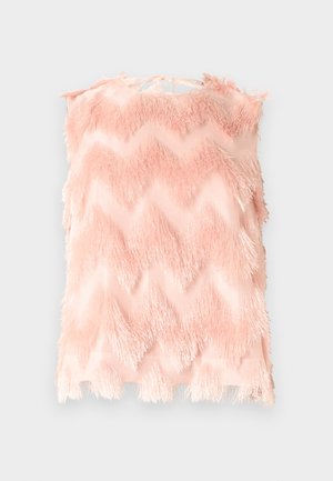 Ροζ αμάνικη μπλούζα με ζικ-ζακ σχέδιο, κατασκευασμένη από απαλό ύφασμα με φράντζες, δεμένη με φιόγκο στο πίσω μέρος του λαιμού.