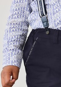 Biała koszula z niebieskim wzorem tekstowym "BAKER", w zestawie z ciemnonawigującymi spodniami z bocznym detalem i regulowanymi niebieskimi szelki.