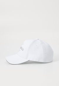 Cappellino da baseball bianco in cotone, con visiera curva, cinturino regolabile sul retro e logo argentato sul davanti.