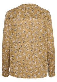 Langärmliges Hemd aus senfgelbem Stoff mit einem kleinen floralen Muster in Weiß und Schwarz. Mit geknöpften Manschetten und einem Detail am Rückenteil.