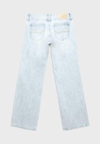 Lyseblå denimjeans med lige ben, to baglommer med dekorativ syning og et beige mærke på linningen.