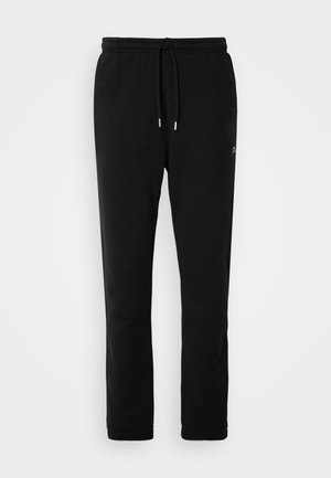 Black sweatpants made of soft cotton, featuring a drawstring waist, tapered legs, and minimal branding in a subtle design.
