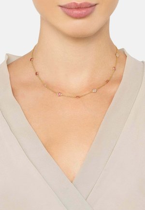 Gold-tone necklace featuring colorful round and oval accents. Delicate chain design with alternating gem-like details in red and clear.
