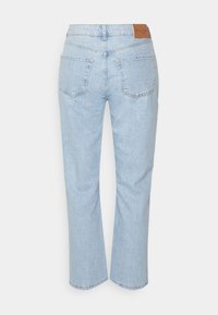Jeans de denim azul claro con corte recto, que cuentan con bolsillos traseros y un parche de piel marrón en la cintura. Textura suave y detalles mínimos.