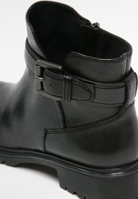 Black leather ankle boot with a smooth texture, featuring a side buckle detail, reinforced seams, and a sturdy rubber sole.