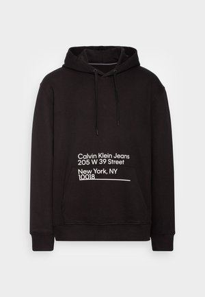 Sudadera negra con bolsillo frontal, capucha ajustable con cordón y detalles en texto blanco que indican direcciones y nombre de la marca en la parte delantera.