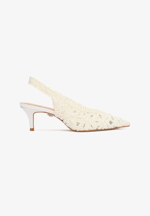 White slingback kitten heel with pointed toe, floral lace overlay, and decorative braided trim along the edges.