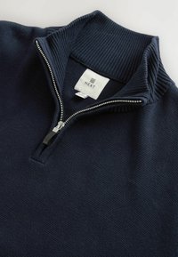 Marineblauer Reißverschluss-Pullover mit geripptem Kragen und strukturierter Stoff. Verfügt über einen kontrastierenden Reißverschluss und ein Etikett mit dem Markennamen "NEXT."