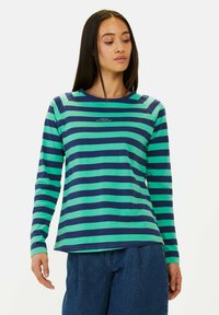 Langsleeve shirt met horizontale groene en marineblauwe strepen. Beschikt over een ronde halslijn en tekst gedrukt op de borst. Zacht katoenmateriaal.