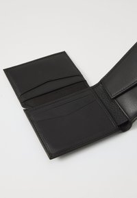 Black leather wallet with a textured interior, multiple card slots, and smooth exterior. Open layout with clean stitching and no hardware.