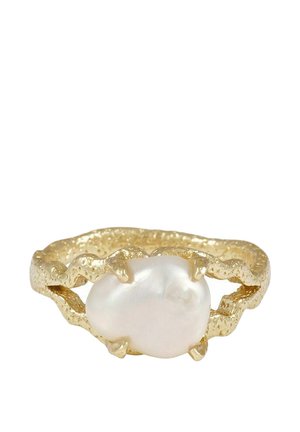 Guldfärgad ring med en oregelbundet formad vit pärla i centrum, med klospännen och öppen banddesign.