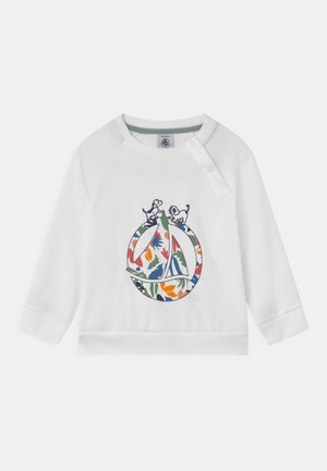 Sweat-shirt blanc à manches longues, avec un design floral coloré au sein d'un logo circulaire, et deux petits chiens en détail brodé.