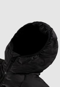 Giacca a vento nera con cappuccio, dall'esterno liscio e lucido. La fodera interna è di un nero uniforme. Presenta una chiusura frontale con zip e bordo elastico attorno al collo.
