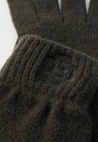 Olivgrüne Handschuhe aus strukturiertem Strickmaterial, mit einem erhabenen Logo in passender Farbe. Rippbund für einen sicheren Sitz.