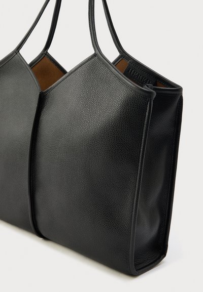 Czarna skórzana torba na ramię o strukturalnej powierzchni, z dwoma długimi uchwytami i minimalistycznym wzorem. Przestronne wnętrze z brązową podszewką.