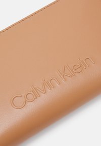 Calvin Klein EMBOSSED LOGO ZIP - Lompakko - lion