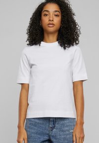 Hvit kortermet t-skjorte med rund hals. Laget av mykt stoff, med en avslappet passform og minimalisk design. Kombinert med denimjeans.