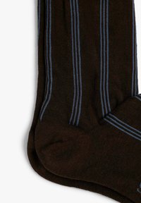 Calcetines marrones con rayas verticales azules, textura acanalada y punta redondeada. El material suave sugiere comodidad y calidez.