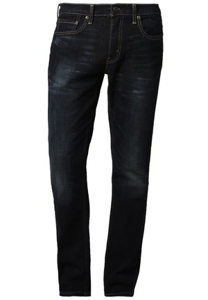 Mørkeblå jeans lavet af denim med en falmet vask, straight fit, fem-lomme design og kontrasterende gul syninger langs sømmene.