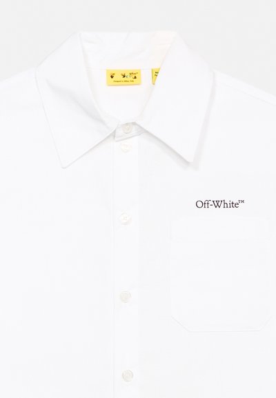 Бяла риза с копчета, с остър яка, джоб на гърдите и бродирано лого "Off-White" над джоба от дясната страна.
