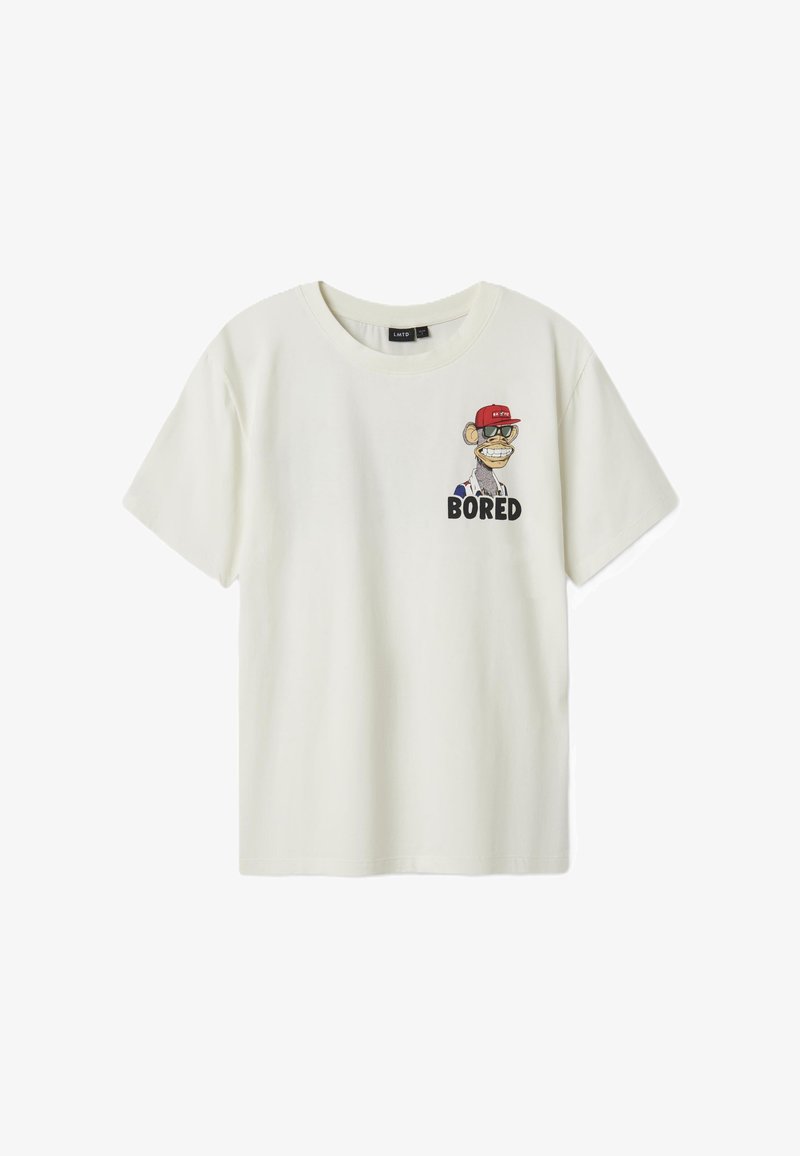 T-shirt beige à manches courtes en coton, ornée d'un graphique de singe cartoon portant une casquette rouge et le mot "ENNUYÉ" en lettres noires en gras.