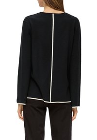 Zwarte longsleeve top met een ronde halslijn en contrasterende witte stiksels langs de achternaad en de zoom, gemaakt van zachte, gestructureerde stof.