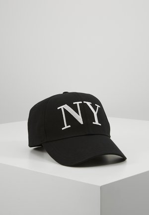Zwarte honkbalpet met witte geborduurde letters "NY", geplaatst op een wit oppervlak tegen een effen grijze achtergrond.