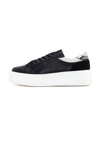 Zapatillas de piel negra con suela de plataforma blanca, que presentan un acabado liso, cierre con cordones y un detalle gris en el talón.