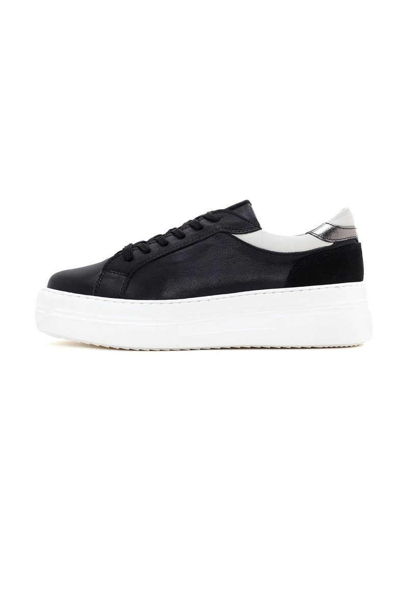 Zapatillas de piel negra con suela de plataforma blanca, que presentan un acabado liso, cierre con cordones y un detalle gris en el talón.