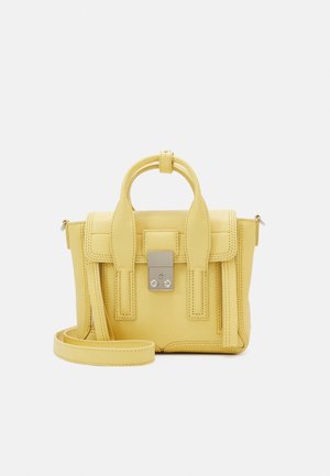 Petit sac à main en cuir jaune avec poignées supérieures, rabat frontal, serrure argentée et bandoulière amovible sur fond blanc.
