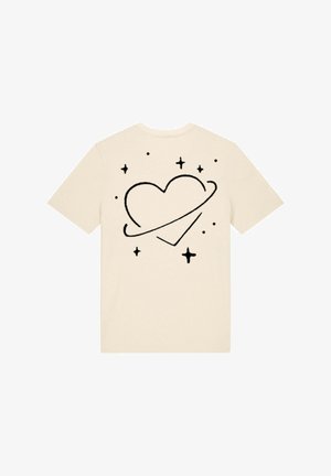 T-shirt beige présentant un graphique de cœur noir entouré d'étoiles et d'un anneau, manches courtes, col rond, en coton doux.