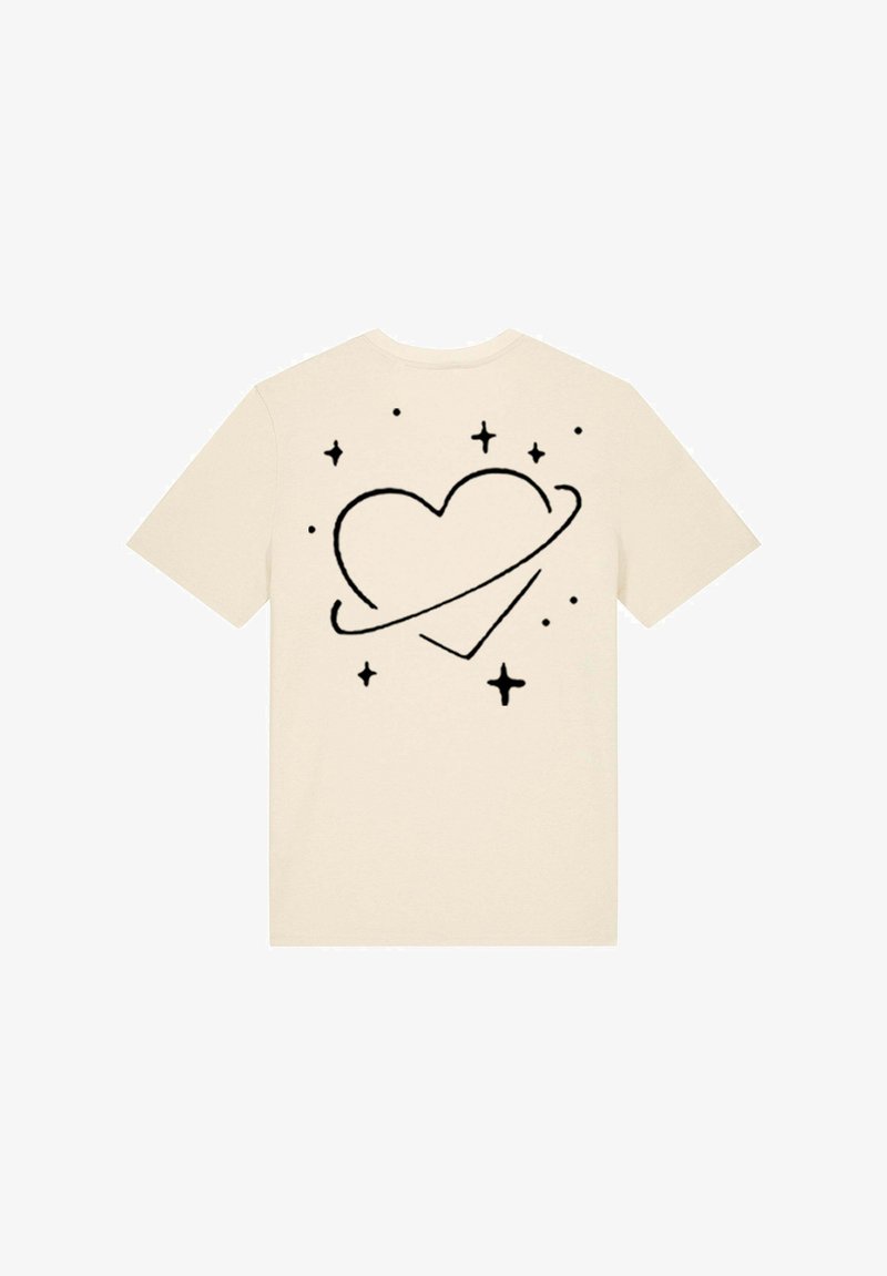T-shirt beige présentant un graphique de cœur noir entouré d'étoiles et d'un anneau, manches courtes, col rond, en coton doux.