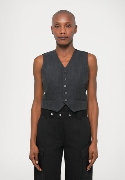 Gilet gris sans manches avec un col en V, doté d'une fermeture à cinq boutons et de poches latérales, associé à un pantalon noir taille haute.