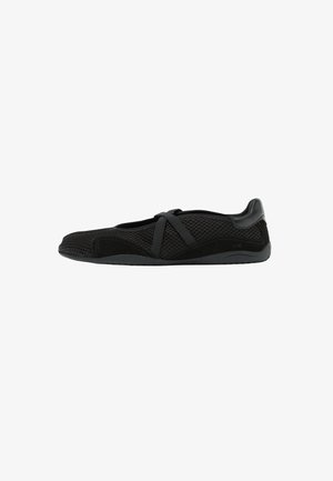 Scarpa piatta nera in mesh con cinturini elastici incrociati e dettagli in camoscio, progettata per un comfort leggero e per un uso casual.