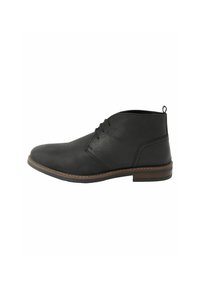 Botas de cuero negras hasta el tobillo con una textura suave, punta redondeada, minimalismo en el cordón y una suela de goma cosida en marrón. Incluye una tab de tiro.