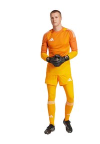 Uniforme da portiere di colore arancione brillante, composto da una maglia a maniche lunghe e pantaloni corti. Include guanti neri e strisce bianche a contrasto sulle gambe.